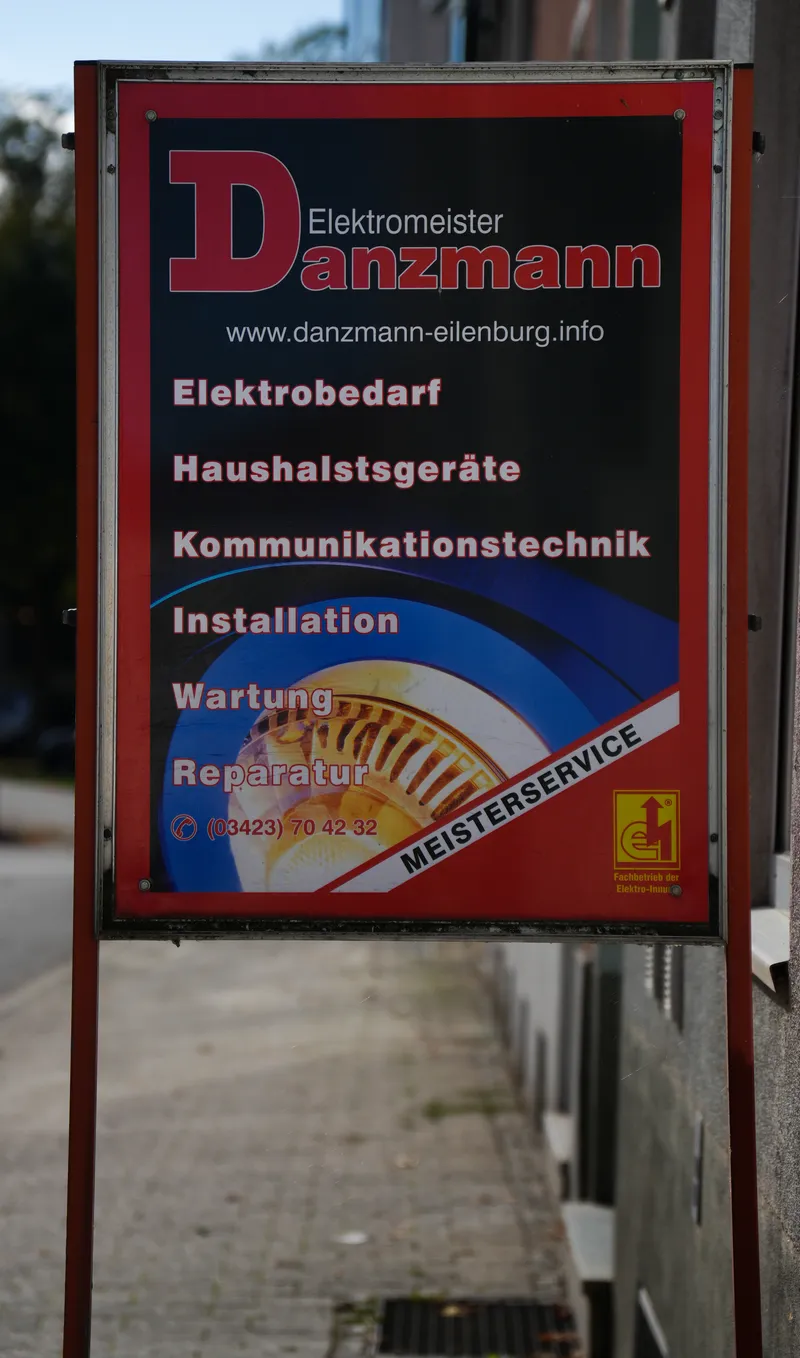 Werbetafel vor dem Laden: Elektrobedarf, Haushaltsgeräte, Kommunikationstechnik, Installation, Wartung und Reparatur
