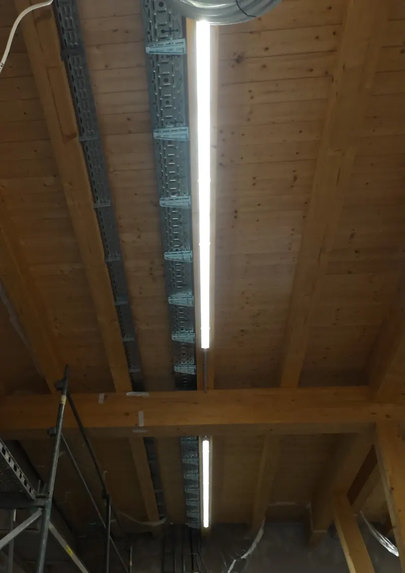 LED-Lichtleiste an einer offenen Holzbalkendecke