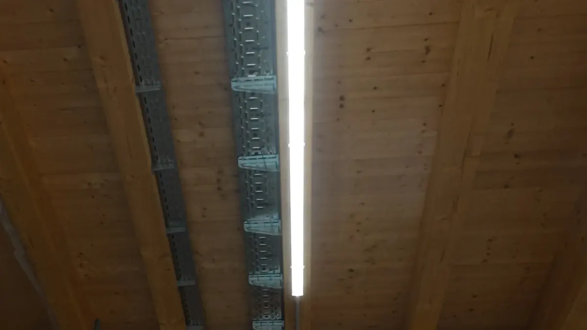 LED-Lichtleiste an einer offenen Holzbalkendecke