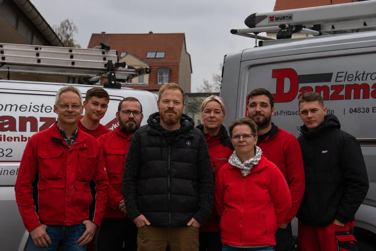 Das Team von Elektromeister Danzmann vor den Firmenwagen